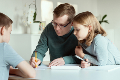 Parent helping children with schoolwork image